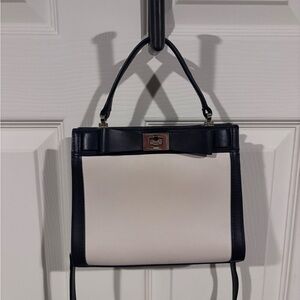 Kate Spade Black and Cream purse. Offers top-handle and crossbody straps.
